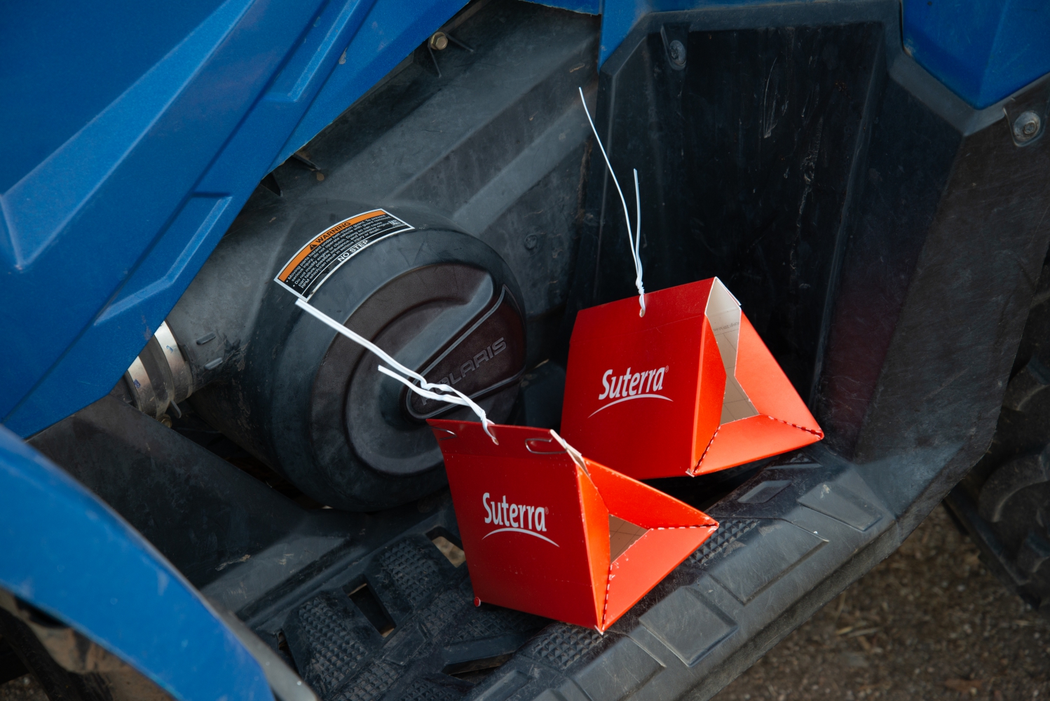 Two Suterra small paper delta traps on a quad bed.